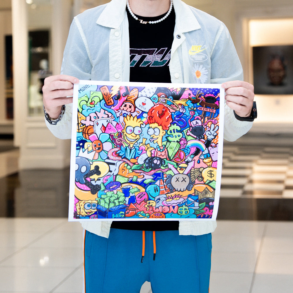 Person holding a colorful art print with various symbols and designs.