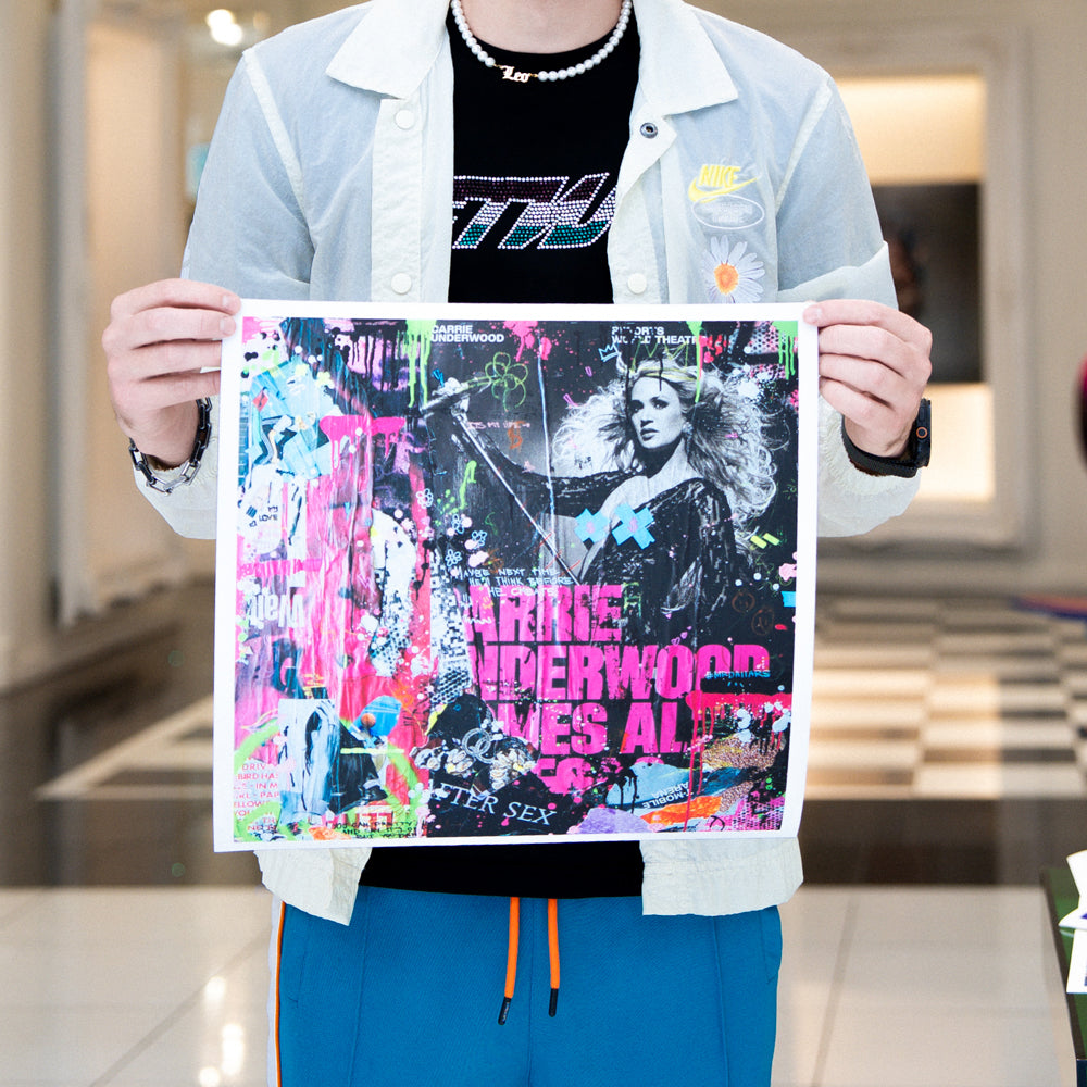 Person holding a colorful album cover with a blurred indoor background