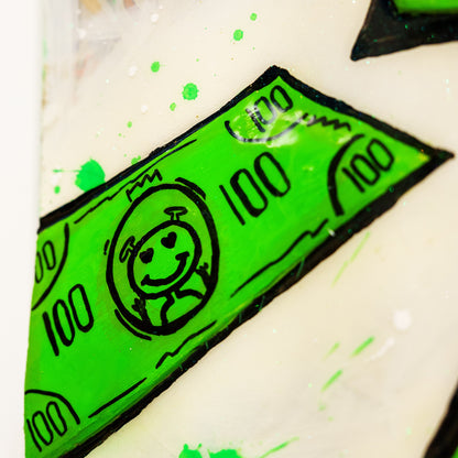 Close-up of a green 100 dollar bill sticker on a white surface with green splashes.