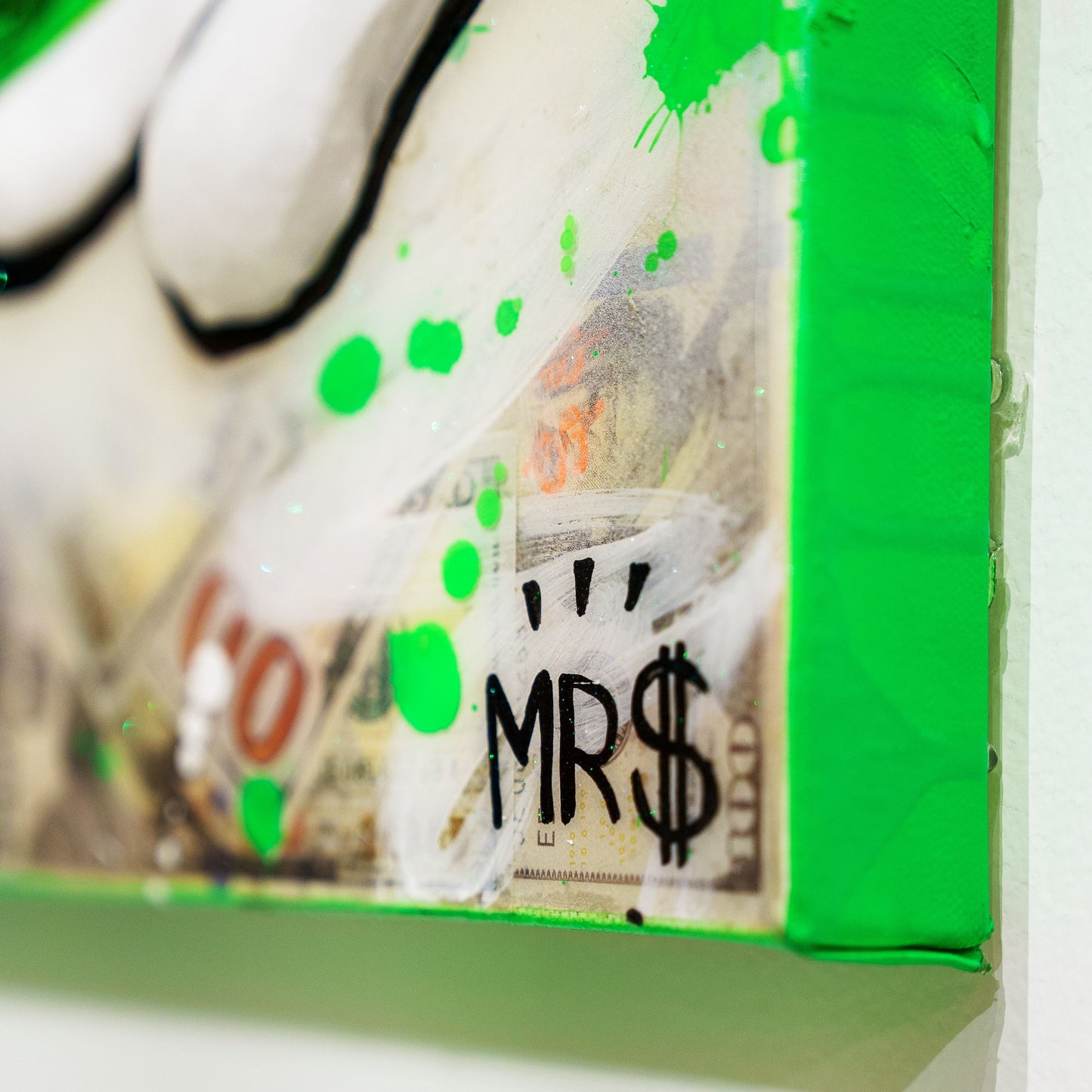 Green package with money and 'MR $' text, possibly a product or packaging design.