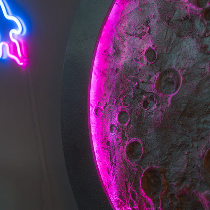 Neon sign of a cat and moon with pink and blue colors on a dark background