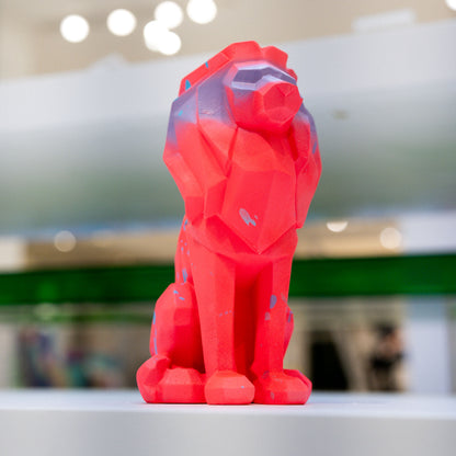 Red geometric bear figurine on a blurred indoor background
