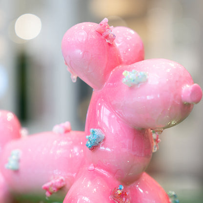 Close-up of a pink balloon animal with decorative elements on a blurred background