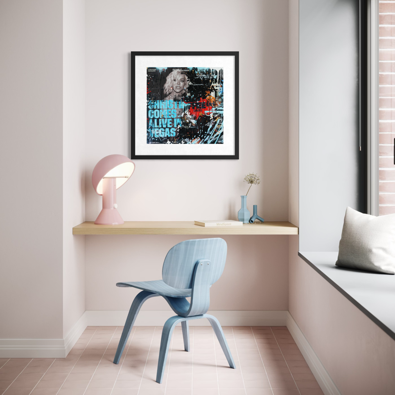 Modern room interior with a desk, chair, and framed artwork on a wall.