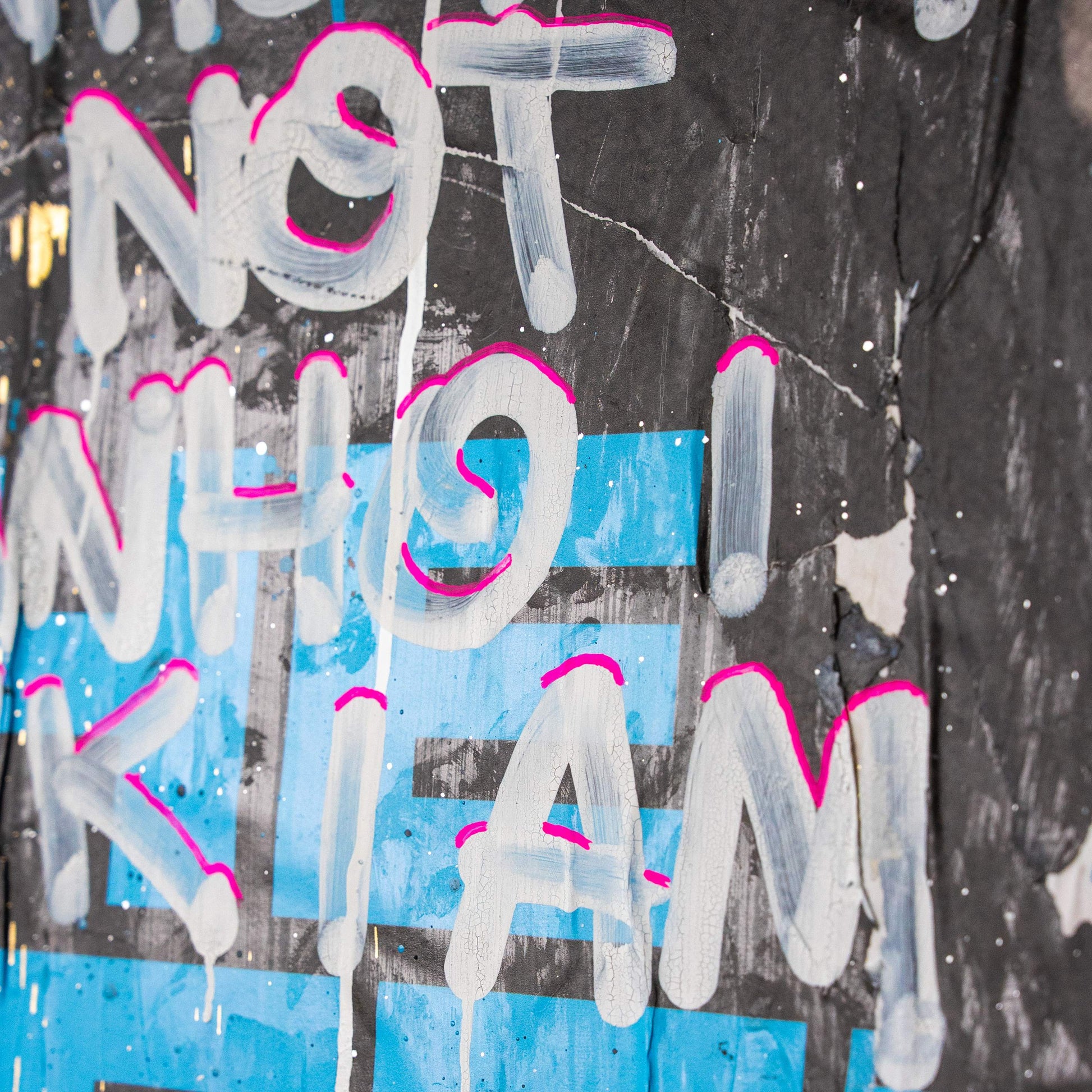 Graffiti-style text on a textured wall with colorful accents